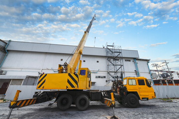 Industrial crane working and lifting power generator under sunlight and blue sky, heavy equipment crane