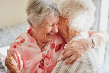 Happy, hug and senior woman friends laughing in the bedroom of a retirement home together. Smile,...