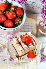 Top view of cream cake with strawberries  and fresh fruits in the bowl