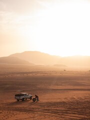 Beduin man changing the tire on his jeep in the Wadi Rum desert. 