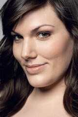 Fototapeta premium Woman closeup, natural beauty and portrait with skincare and dermatology. Cosmetics, happy face and young female person from Italy in studio with smile from skin treatment with makeup and wellness