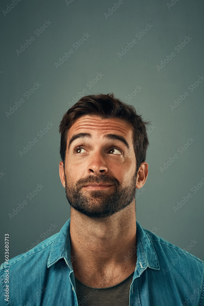 Poster man, face and thinking on mockup space for idea, plan or wondering against a grey studio background.