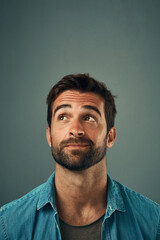 Man, face and thinking on mockup space for idea, plan or wondering against a grey studio...