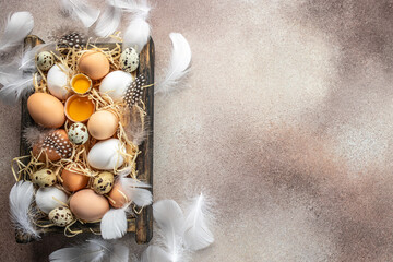 Eggs and yolks in a wooden box on a light background. top view