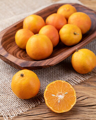 Cravo or rose lemons in a bowl over wooden table