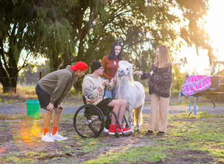 group of teenagers - one in a wheelchair - with miniature horse
