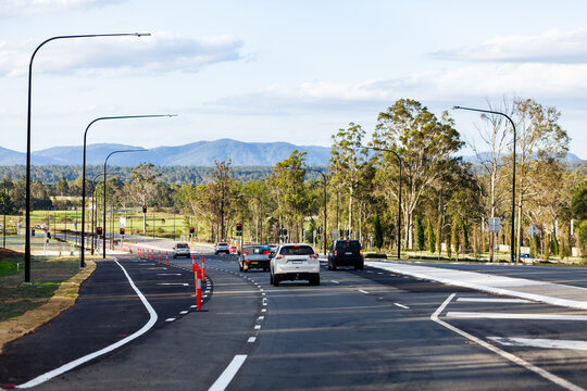 Newly built road infrastructure with cars driving on it towards traffic lights