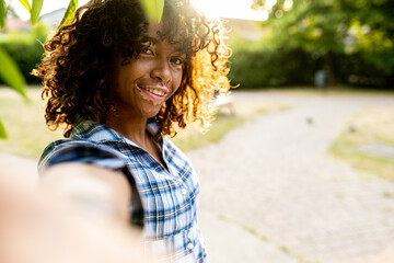 young biracial woman taking selfie on sunset outside, female person with genetic vitiligo smiling at the camera, happy people and body positive concepts
