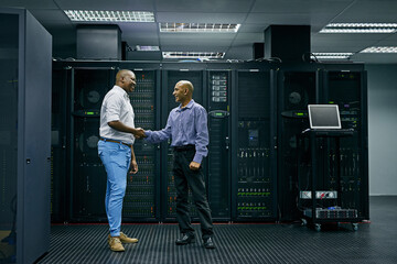 Handshake, partnership or men in server room of data center worker with a thank you hand shake for...