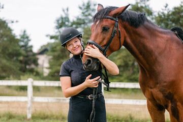 Female rider hand gently caressing beautiful thick red horse mane, close up shot. Equitation and...