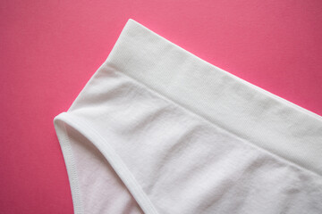 Close-up of white briefs, wide side with high ribbon, seamless on a pink background. Detail, hygiene, everyday, underwear, elegant, minimalism, sale, advertising. Top view