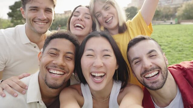 Happy multiracial friends taking video selfie outside