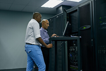 Server room, people or technicians coding on computer together for a cybersecurity glitch with...