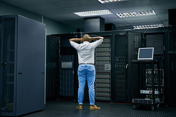Server room, IT support or electrician with a hardware problem stressed with maintenance or glitch crisis. Confused or back of worried technician or electrical engineers in information technology