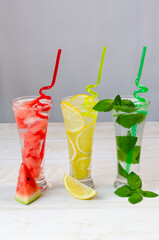 Three glasses with various soft drinks to quench your thirst on a hot summer day, watermelon, mint...