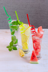 Three glasses with various soft drinks to quench your thirst on a hot summer day, watermelon, mint...