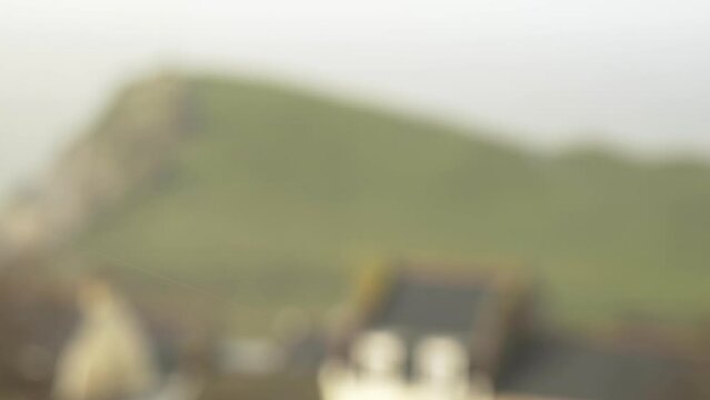 Rain drops in wind with blurry hillside in background in spring