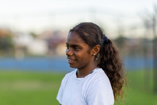 head and shoulders of one aboriginal girl looking away with blurry background