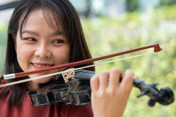 An attractive woman learning musician plays the violin at home.  Composer creating songs with string instruments. Dreamy violinist fingers pressing strings on violin