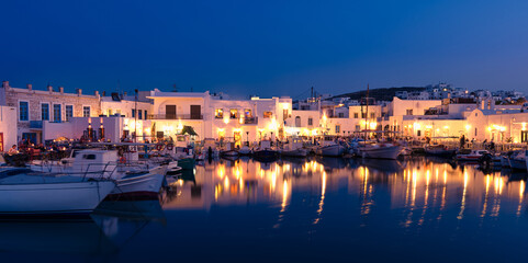 Fototapeta premium Traditional Greek fishing village and harbour after sunset, boats