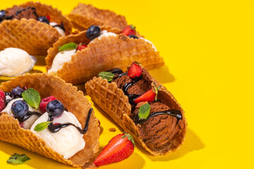 Various sweet taco ice creams. Waffle taco shells with chocolate and vanilla flavour ice cream with different fruits, berry, toppings