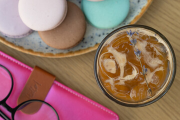 Iced latte coffee with lavender in glass on cafe table background. Summer fresh coffee drink