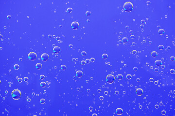 Water bubbles background. Macro oxygen bubbles in water over blue background.