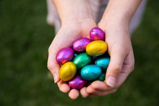 handfuls of easter eggs held by a child