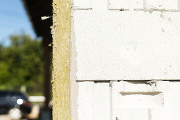 Facade insulation with mineral wool, thermal improvement and energy saving. Modern farmhouse renovation covering with stone wool panels close up. House insulation concept