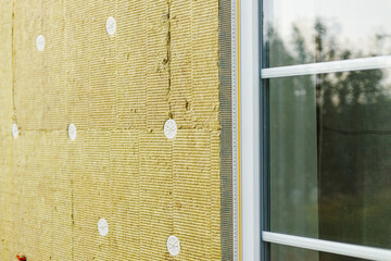 Facade insulation with mineral wool, thermal improvement and energy saving. Modern farmhouse...