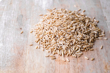 oat seeds heap isolated on wooden table background. top view with copyspace