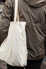 Tote bag on the shoulder. Person in the market.
