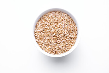 oat seeds in a round bowl isolated on wooden background top view
