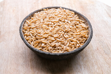 oat seeds in a black plate isolated on white background top view
