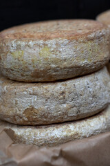 Aged cheese. Round pieces of cheese at the market.