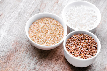 Rice, buckwheat, amaranth seeds. Gluten free seeds in bowls. Top view with copyspace.