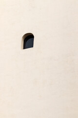 One lonely window on a large wall. Minimalist photo.