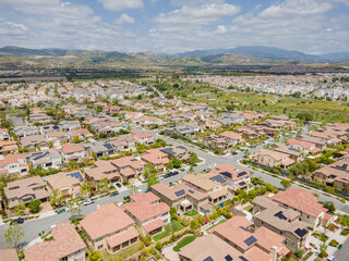 Irvine, California – May 7, 2023: aerial drone view toward Cruiser Irvine CA townhomes including Great Park with new houses, homes, sky, mountain, cloud