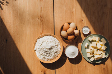 The process of preparing a cupcake in the kitchen. Flat lay on a wooden table of baking ingredients, sugar, eggs, flour, butter