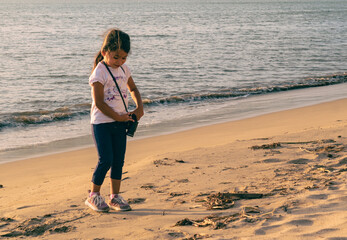girl at the beach on a sunny afternoon using binoculars, walking and kicking the sand, Girl Looking...