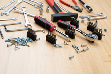 A set of working tools, a hammer, a screwdriver, sockets for repair on a bamboo, wooden background. Top view