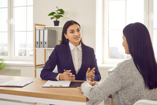 Two women meeting in the office. HR manager talking to a candidate at a job interview. Young business advisor, loan broker or lawyer discussing something with her client