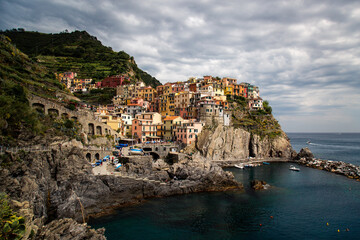 Fototapeta na wymiar Viewpoint of Manarola, in a cloudy day with its old buildings on the rock, Cinque Terre, Liguria, Italy