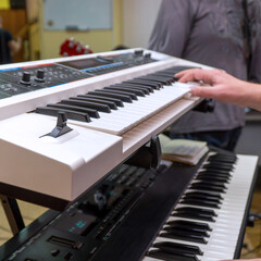 A pianist or keyboardist plays a synthesizer