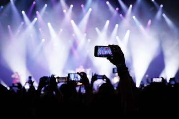 Fototapeta na wymiar People at concert shooting video or photo using mobile phones.