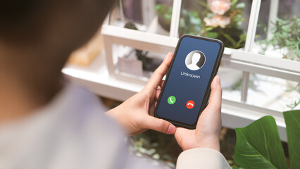 Woman holding mobile phone with incoming call from unknown caller. scammer or stranger, Hoax person with fake identity, Prank caller, anonymous, smartphone, Fraud or phishing concept,