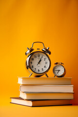stack of books and clock on yellow background created with AI generative technology