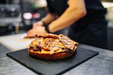 chef hand cooking big large cheese burger on restaurant kitchen. step by step