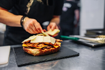 chef hand cooking big large cheese burger on restaurant kitchen. step by step