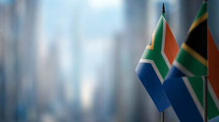 Small flags of the South Africa on an abstract blurry background